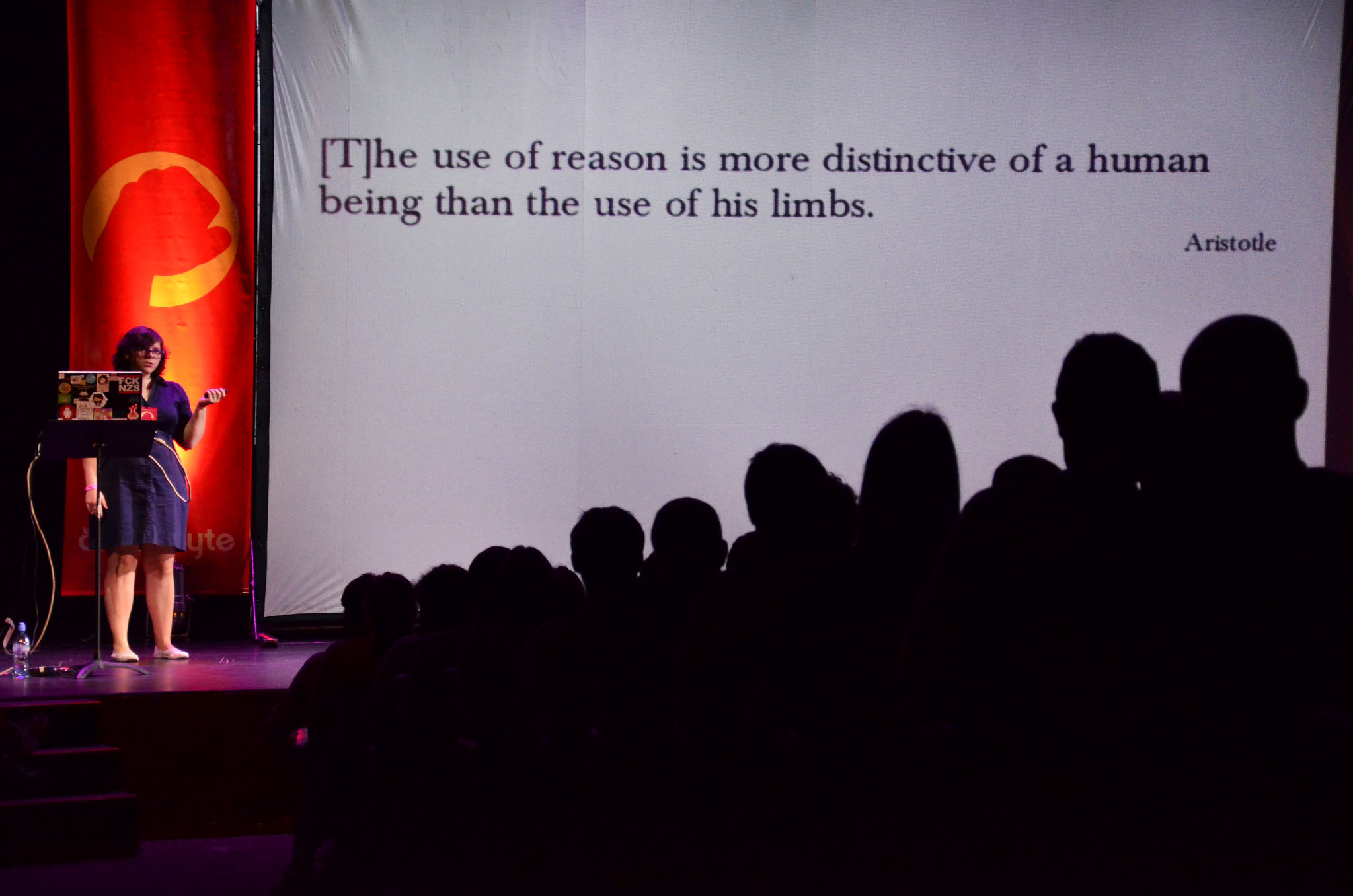 A photo of me on stage at RubyConf Argentina 2014. Behind me there's a screen with a slide that has a quote from Aristotle on it: 'The use of reason is more distinctive of a human being than the use of his limbs'. Image credit: Estela Garcia Fotografa Profesio