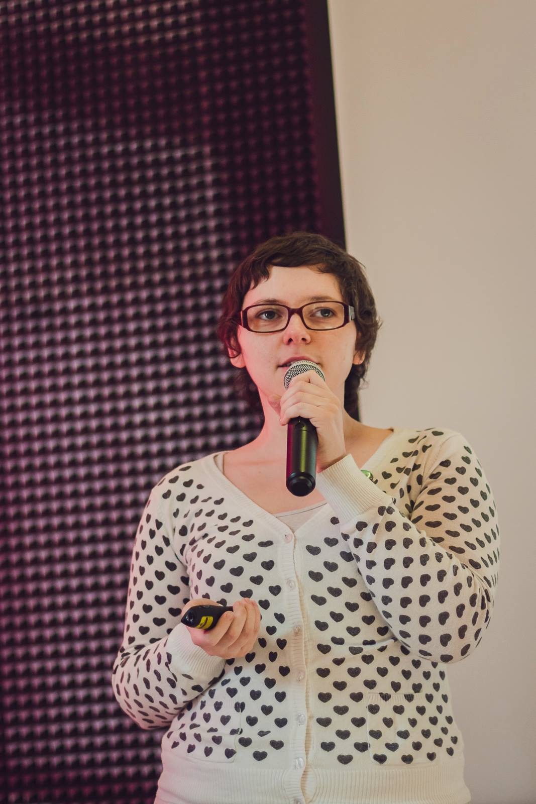 A photo of me standing on stage at Rails Girls Warsaw, explaining how a Ruby on Rails app is like a bento box.